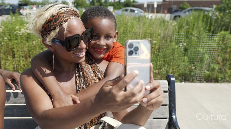 Smiling mother and son taking selfie outdoors