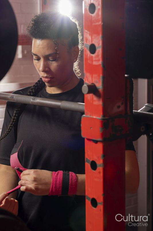 Woman bandaging her wrists before weightlifting training
