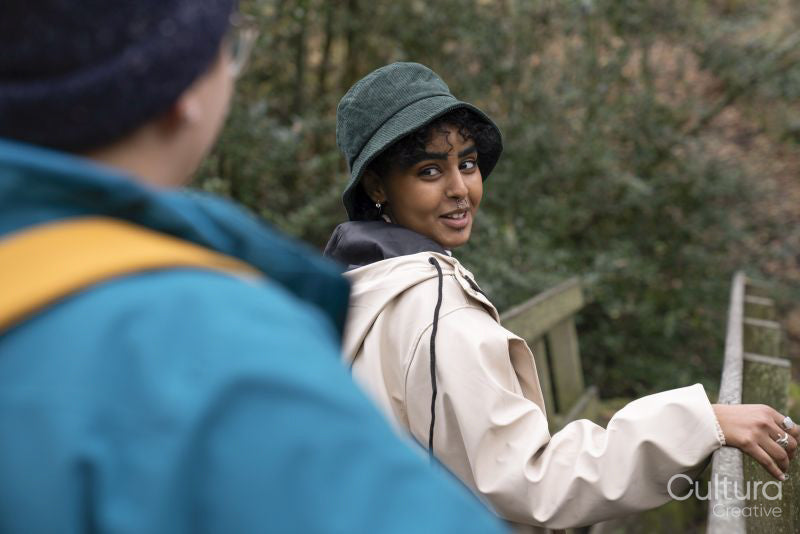 Smiling female hikers on bridge in forest