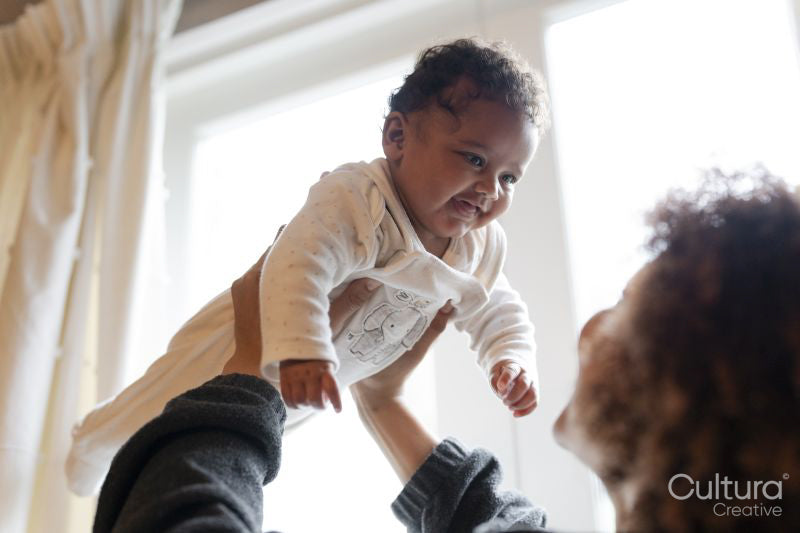 Mother holding aloft baby daughter