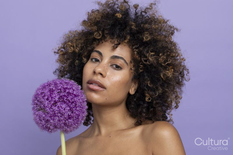 Portrait of brunette holding purple flower