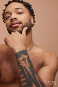 Studio portrait of handsome shirtless man with tattooed hand