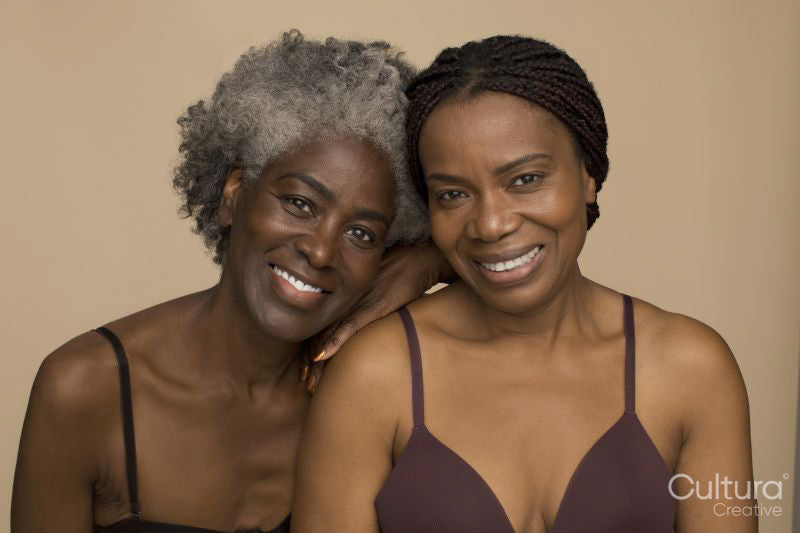 Studio portrait of two smiling women wearing lingerie