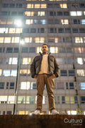Portrait of young man standing in front of block of flats