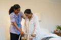 Nurse helping senior lady in her room at nursing home