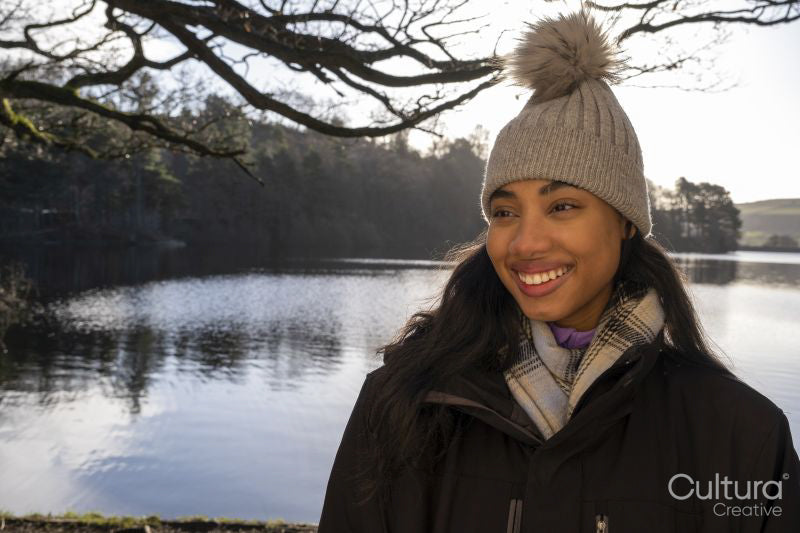 Smiling young woman in knit hat at lake