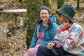 Smiling female friends sitting in forest