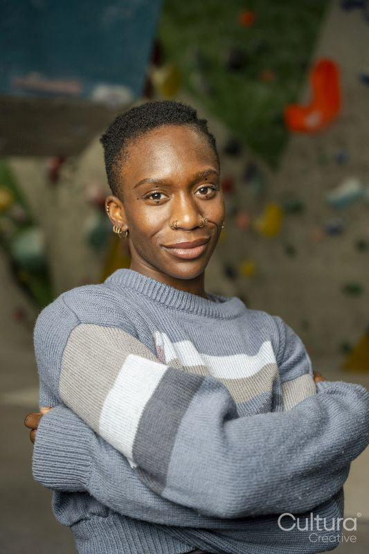 Portrait of smiling woman with climbing wall in background