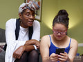 Mother with daughter with Down Syndrome looking at smart phone at home