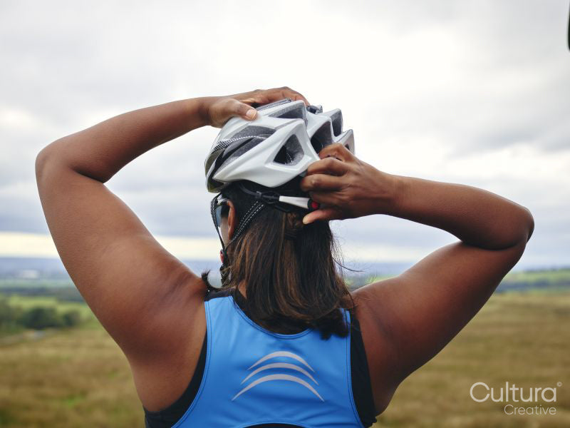 Woman putting on bicycle helmet
