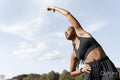 Young woman stretching in park