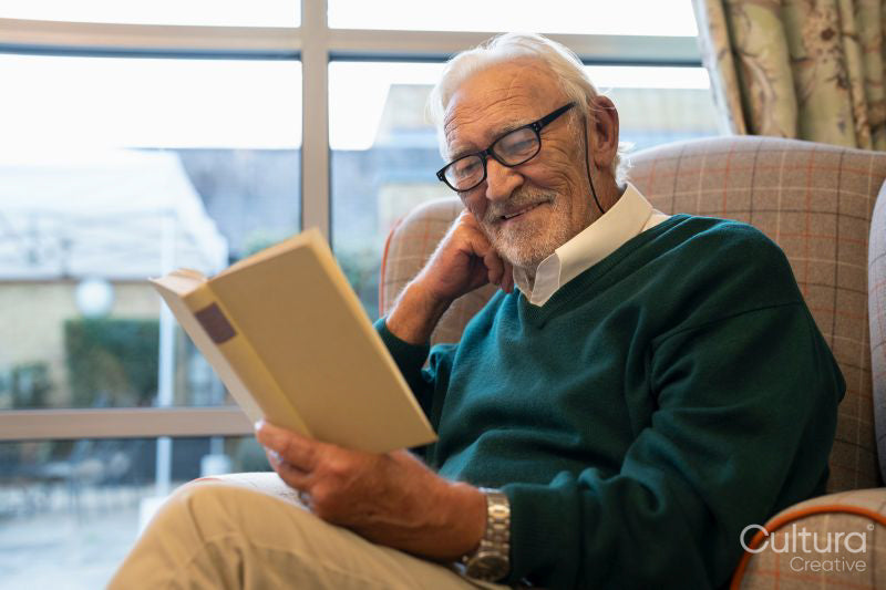 Smiling senior man reading book