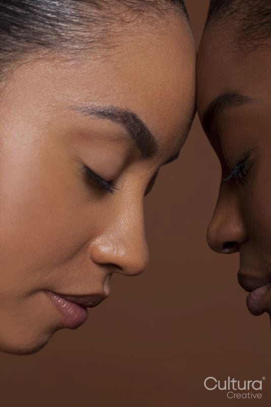 Young women with closed eyes against brown background
