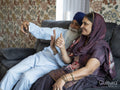 Senior couple in traditional clothing having video call on phone