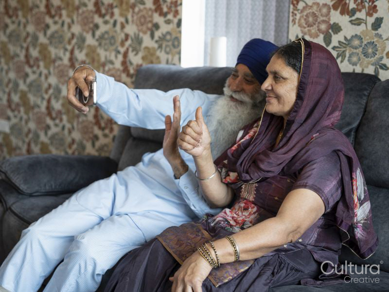 Senior couple in traditional clothing having video call on phone