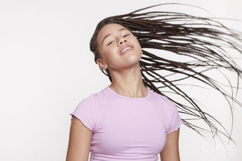 Studio portrait of smiling girl with long braided hair