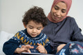 Mother and son using digital tablet at home