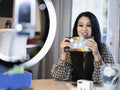 Woman recording unboxing video at home