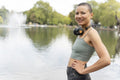 Portrait of athletic woman standing by pond in park