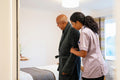 Nurse helping senior man in his room at nursing home