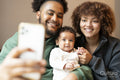 Family with baby girl taking selfie at home