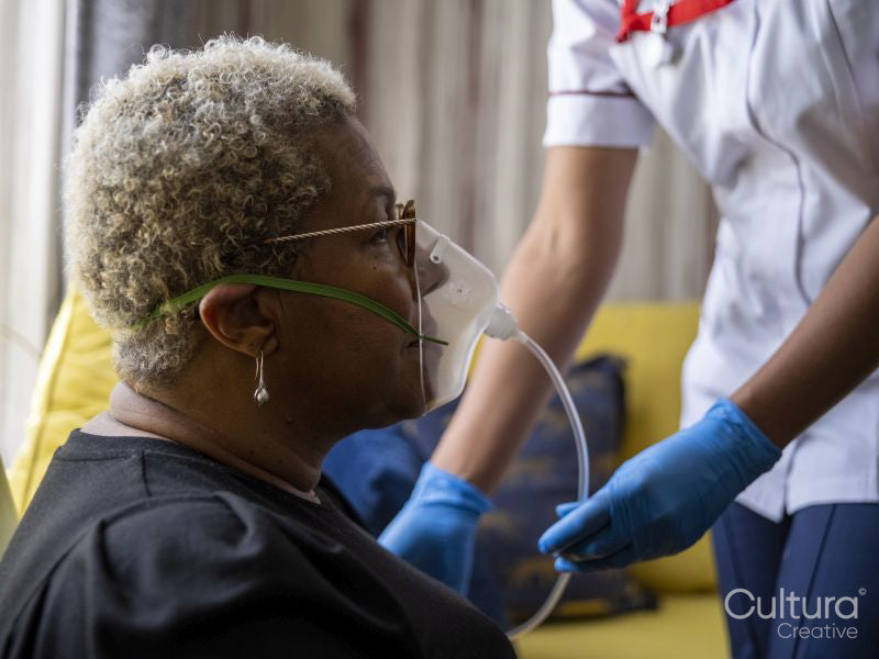Nurse helping patient use oxygen mask