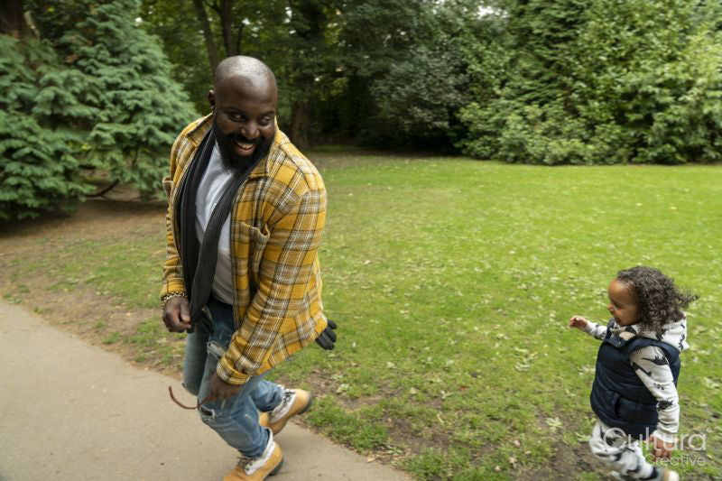 Smiling man playing with daughter in park