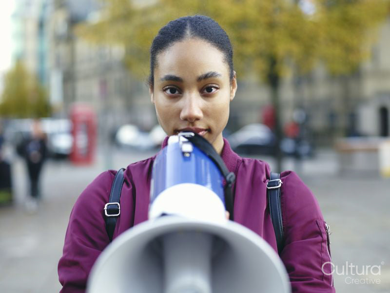 Portrait of young woman holding bullhorn