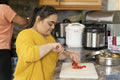 Woman with down syndrome preparing food with mother in kitchen