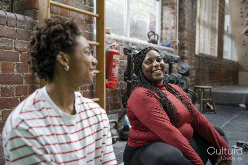 Mother and daughter doing relaxation exercises in gym