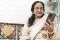 Portrait of senior woman using smart phone in living room