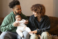 Parents sitting on sofa with baby daughter