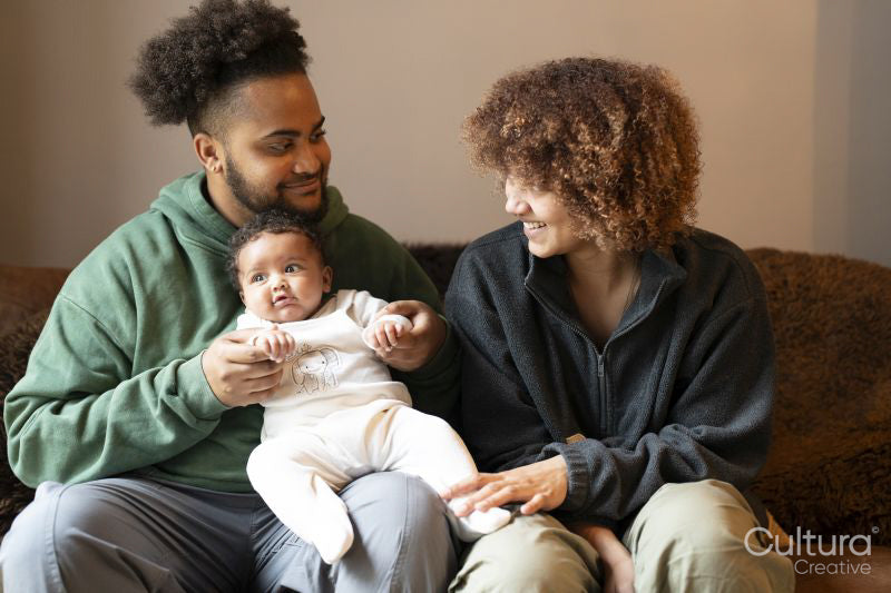 Parents sitting on sofa with baby daughter