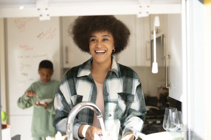 Mother and son washing dishes and cooking in kitchen