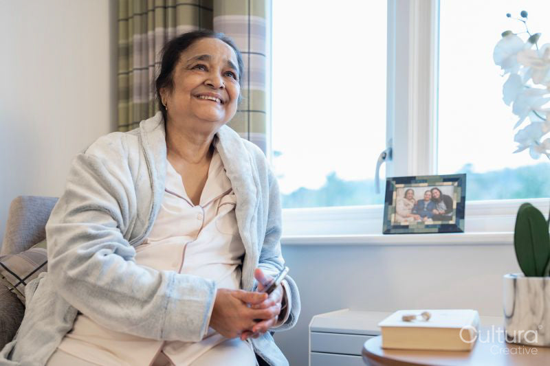 Senior lady sitting in bedroom at nursing home