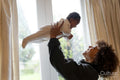 Mother holding aloft baby daughter