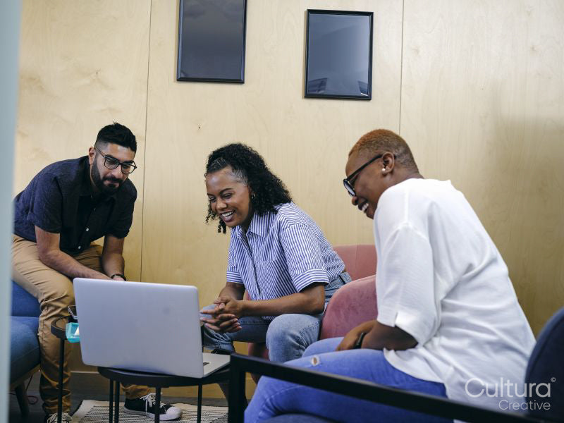 Coworkers looking at laptop in office