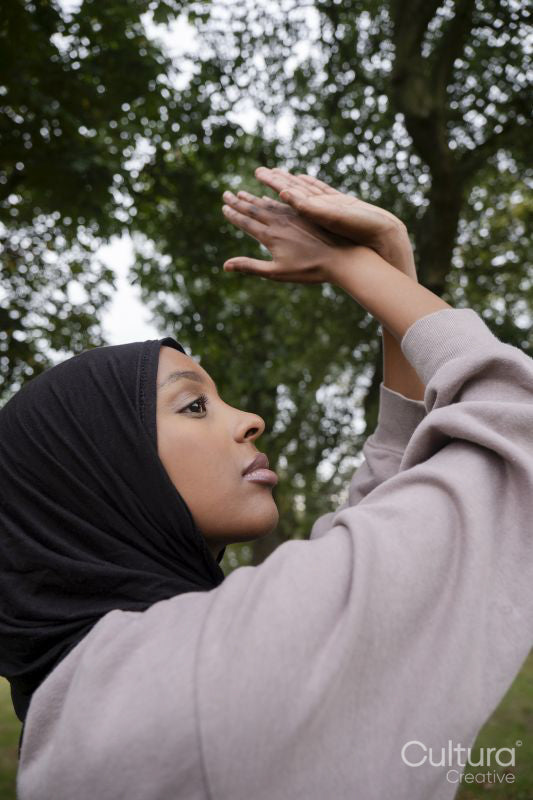 Portrait of woman in hijab practicing yoga in park