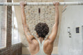 Woman performing chin-up exercise next to climbing wall