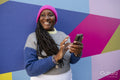 Beautiful woman using phone on colorful background