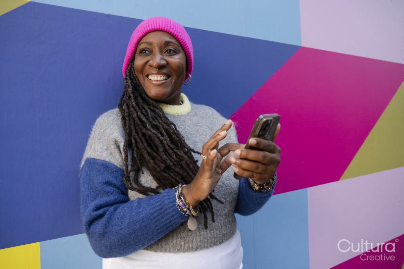 Beautiful woman using phone on colorful background