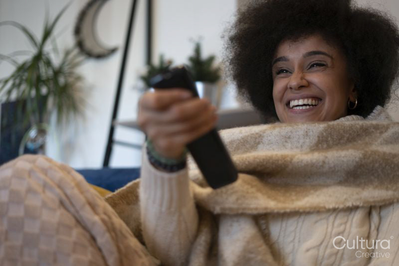 Smiling woman watching TV at home