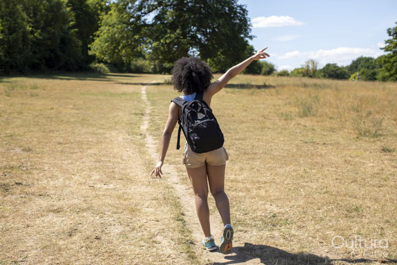 Young woman hiking in countryside, rear view