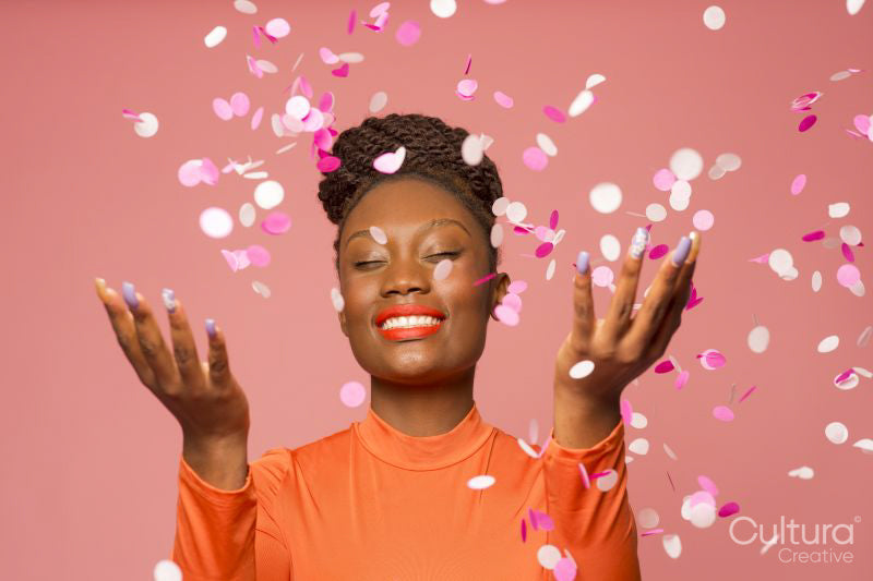 Studio shot of stylish woman with falling confetti