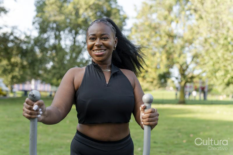 Smiling young woman exercising in outdoor gym