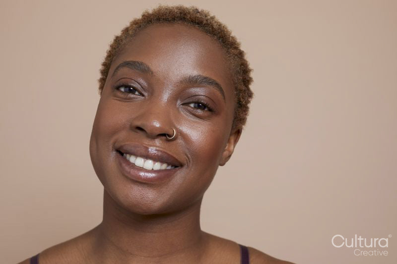 Studio portrait of smiling woman with nose ring
