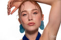 Studio portrait of a woman in a blue dress and large blue earrings