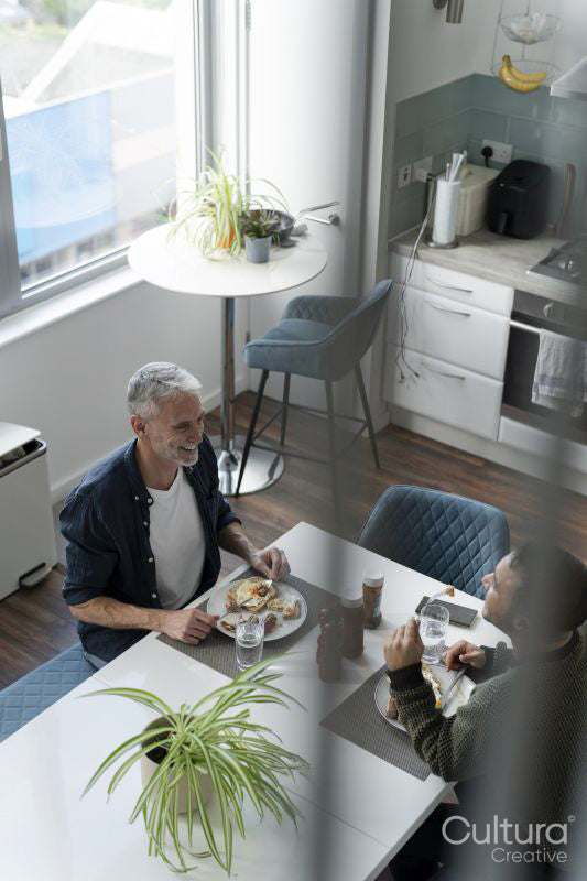 Male couple eating breakfast at home