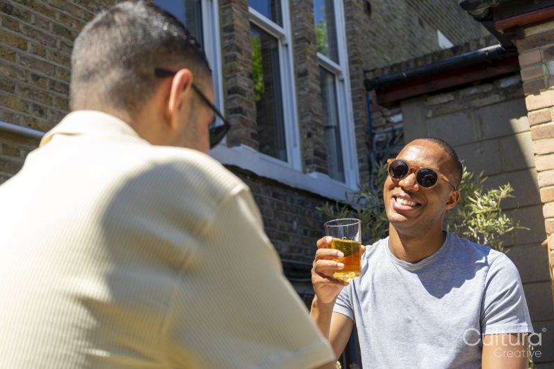 Smiling couple enjoying beer in rooftop garden