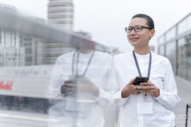 Non binary office worker posing against office buildings